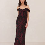 Woman wearing a black and dark red floral off-shoulder gown on a white background