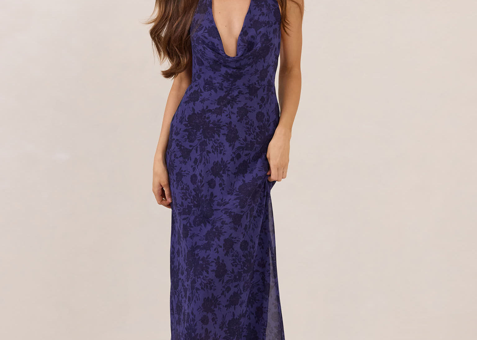 Woman wearing a deep purple floral dress against a plain background