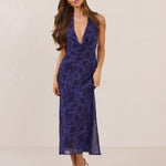 Woman wearing a deep purple floral dress against a plain background