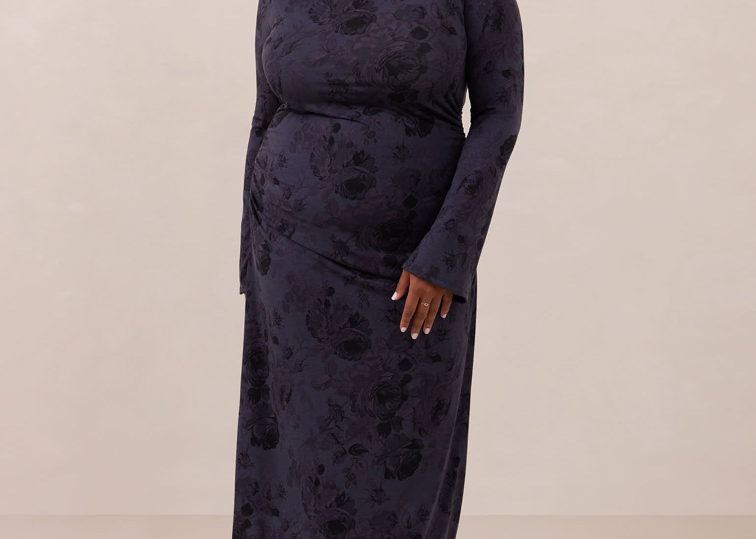 Woman wearing a dark blue patterned dress against a plain background