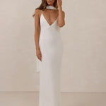 Woman wearing a white dress against a plain background