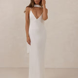 Woman wearing a white dress against a plain background