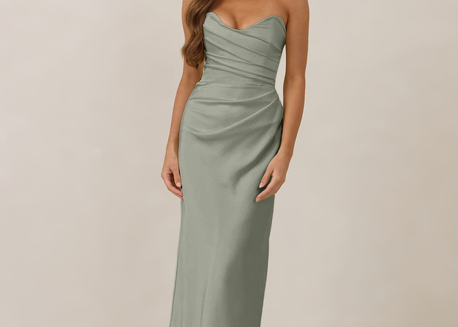 Woman wearing a strapless true sage dress standing against a plain background