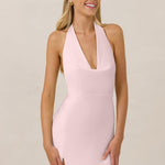 Woman wearing a pink halter neck dress against a beige background