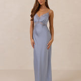 Woman wearing a light blue evening gown with lace detailing on a beige background