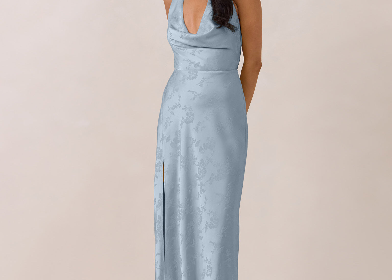 Woman wearing a light blue evening gown against a plain background