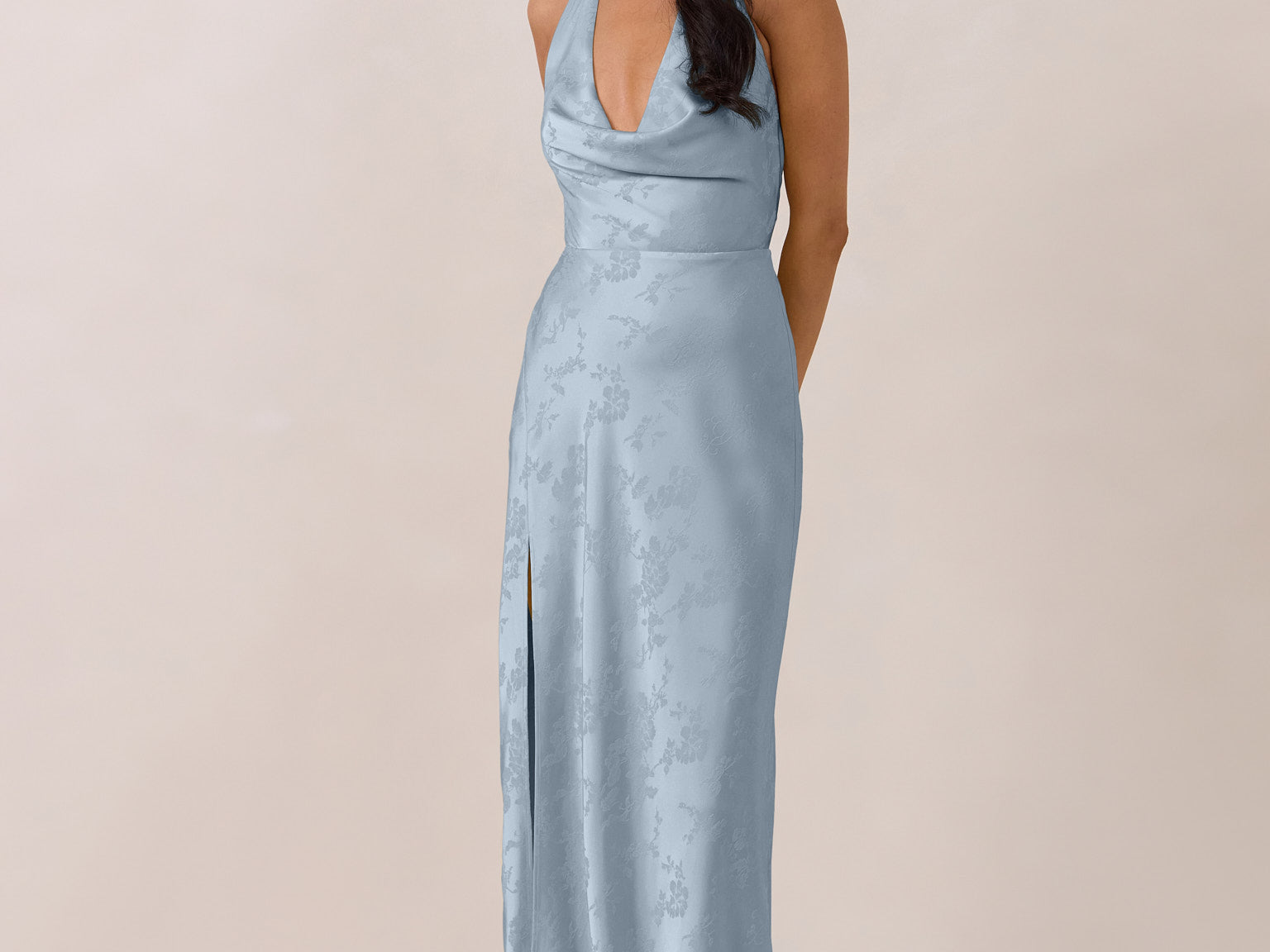 Woman wearing a light blue evening gown against a plain background