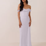 Woman wearing a light purple off-shoulder mid length dress against a plain background