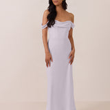 Woman wearing a light purple off-shoulder mid length dress against a plain background