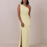 Woman wearing a light yellow one-shoulder gown against a plain background