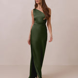 Woman wearing a green one-shoulder dress against a beige background