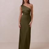 Woman wearing a green one-shoulder dress against a beige background