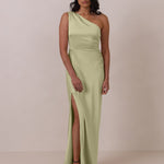 Woman wearing a pistachio one-shoulder gown with a slit on a plain background