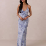 Woman wearing a blue floral dress against a beige background