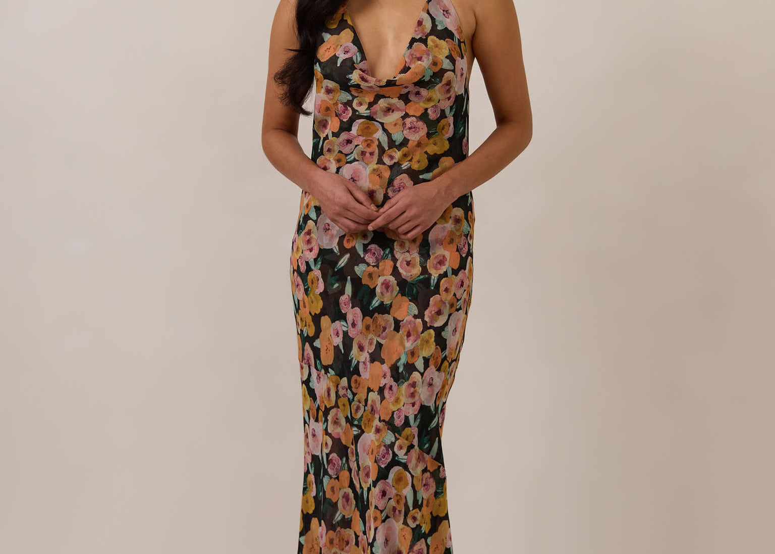 Woman wearing a floral dress against a plain background