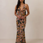 Woman wearing a floral dress against a plain background