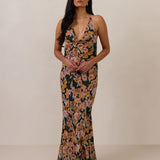 Woman wearing a floral dress against a plain background