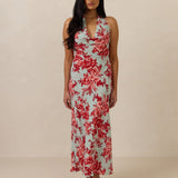 Woman wearing a teal and red floral dress against a beige background