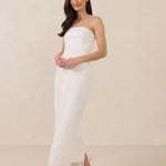 Woman wearing a strapless lace maxi dress on a plain background